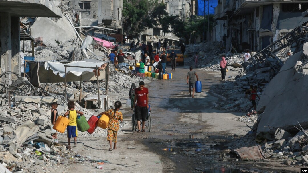 Palestinienii stau la coadă pentru a umple recipientele cu apă în orașul Khan Yunis din sudul Fâșiei Gaza pe 14 iulie 2024.