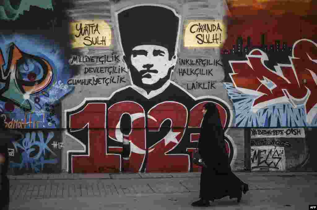 A woman walks past a graffiti portrait of the founder of modern Turkey, Mustafa Kemal Ataturk, in Istanbul. (AFP/Ozan Kose)