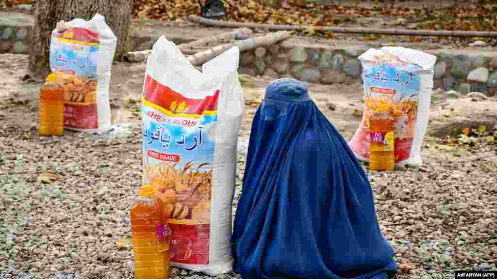  Žena sjedi pored pomoći u hrani koju distribuira lokalna dobrotvorna fondacija u Mazar-i-Sharifu, Afganistan. &nbsp; 