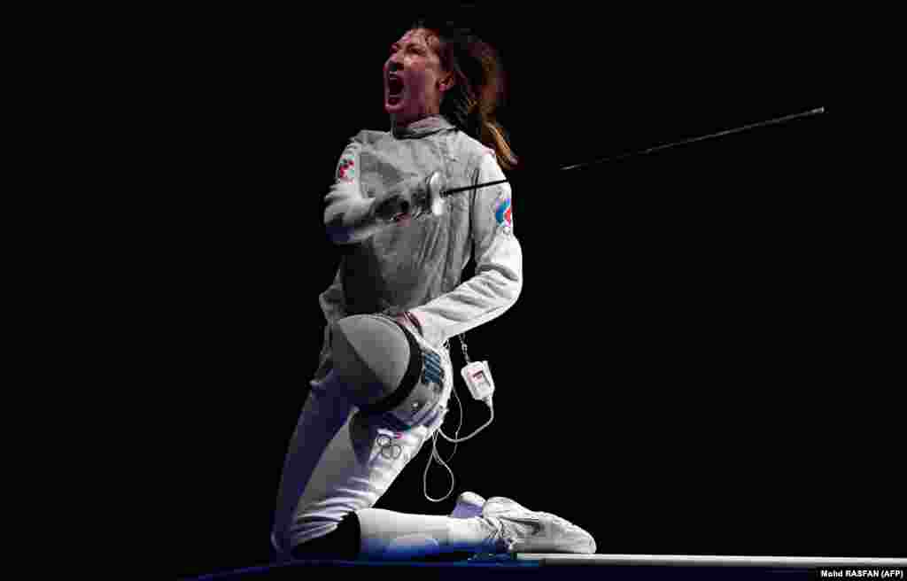 Россиянка Лариса Коробейникова празднует победу над итальянкой Алисой Вольпи в индивидуальном поединке за бронзовую медаль в фехтовании на рапирах среди женщин на Олимпийских играх 2020 года в Токио в зале Макухари Мессе в городе Тиба, Япония, 25 июля 2021 года