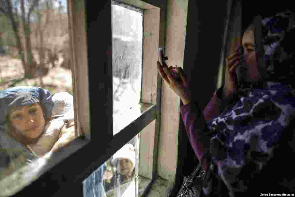 Žena se ogleda u ogledalu dok čeka da dobije svoj glasački listić u Centru za registraciju birača. (Kabul, 30. mart 2014)