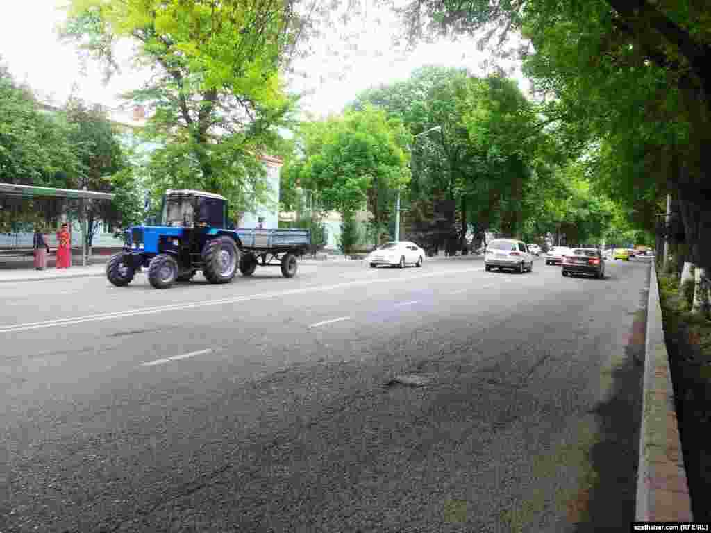 Aşgabadyň k&ouml;&ccedil;eleriniň birinden traktor ge&ccedil;ip bar&yacute;ar