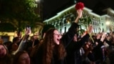 Supporters of Bucharest Mayor Nicusor Dan cheer as he exits his campaign headquarters in Bucharest after winning a presidential election on May 18.