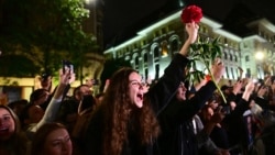 Supporters of Bucharest Mayor Nicusor Dan cheer as he exits his campaign headquarters in Bucharest after winning a presidential election on May 18.