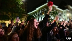 Supporters of Bucharest Mayor Nicusor Dan cheer as he exits his campaign headquarters in Bucharest after winning a presidential election on May 18.