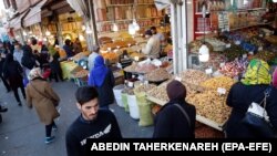 Iranians, shown here shopping at a bazaar in Tehran, have been hit hard by the country's economic crisis.