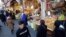 Iranians, shown here shopping at a bazaar in Tehran, have been hit hard by the country's economic crisis.