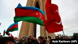 AZERBAIJAN -- Azerbaijanis wave Azerbaijani and Turkish national flags as they celebrate entry of troops in Nagorno-Karabakh's Aghdam region in Baku, November 20, 2020