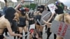 Members of the activist group FEMEN, dressed in scanty "riot police" outfits, pretend to beat up a reporter during a rally against censorship and repression in the Ukrainian media.