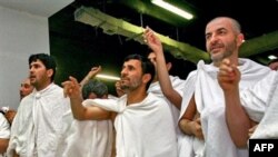 Iranian President Mahmud Ahmadinejad (center) throws stones at a column symbolizing the devil in Mecca.