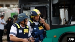 Israeli emergency service officers gather at the site of a Hezbollah missile strike that targeted a bus in the northern Israeli border town of Kiryat Shmona on March 23.