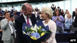 Ursula von der Leyen, az Európai Bizottság újraválasztott elnöke virágcsokrot kap Manfred Webertől, az Európai Néppárt elnökétől az Európai Parlamentben, Strasbourgban 2024. július 18-án