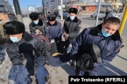 Полиция Республика алаңының іргесінде ер адамды ұстап әкетіп барады. Алматы, 2021 жылғы қаңтар.