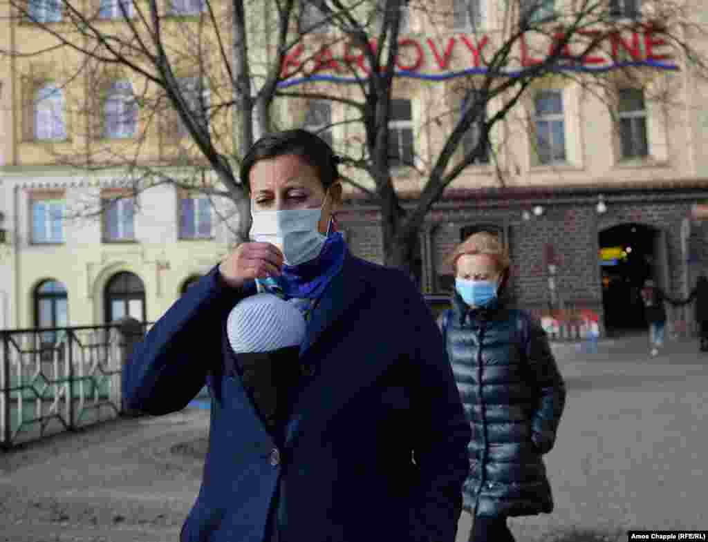 Women -- one carrying a baby, walking through Prague&#39;s Old Town wearing surgical masks. Only a tiny minority of people in the Czech capital are wearing such masks on the street.&nbsp;