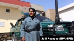 FILE: An Afghan female police officer stands guard outside a police station in Herat (October 2017).