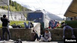 Un grup de migranți, așteptând trenul la granița dintre Italia și Germania