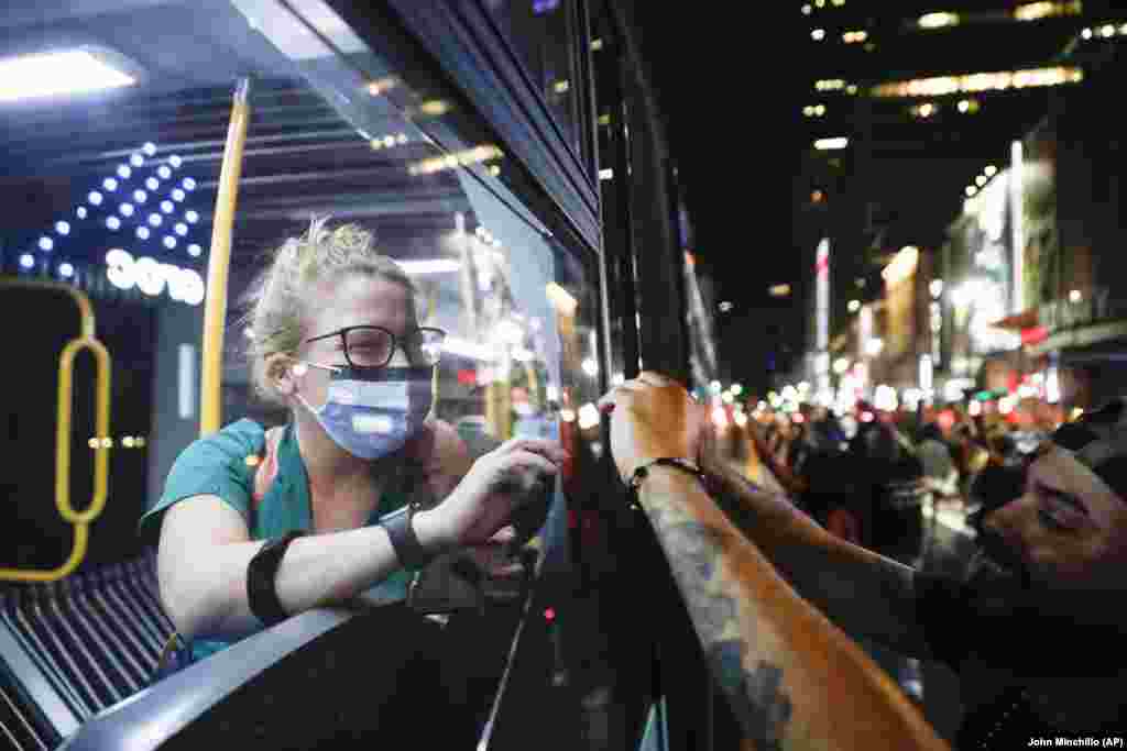 Медик через вікно автобуса вітається із протестувальниками, які всупереч комендантській годині, вийшли на протест. Мангеттен, Нью-Йорк, 4 червня 2020 року
