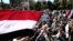 Iranian protesters chant slogans as they hold national flags of Yemen during a demonstration in Tehran on May 8, 2015.