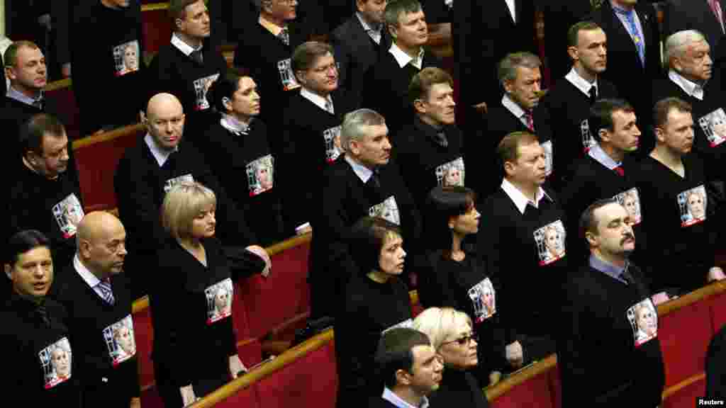 Members of the Batkivshchina (Fatherland) bloc, wearing shirts with a portrait of their leader, imprisoned former Prime Minister Yulia Tymoshenko, listen to the state anthem before the first session of the newly elected parliament in Kyiv. (Reuters/Anatolii Stepanov)