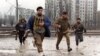 RUSSIA - Chechen fighters run across the street, trying to avoid sniper fires as they head for the presidential palace in dowtown Grozny on January 12, 1995