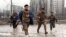 RUSSIA - Chechen fighters run across the street, trying to avoid sniper fires as they head for the presidential palace in dowtown Grozny on January 12, 1995