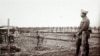 An undated photo shows German soldiers crossing a field, offering to surrender to French troops at a listening post in a trench at Massiges, France.