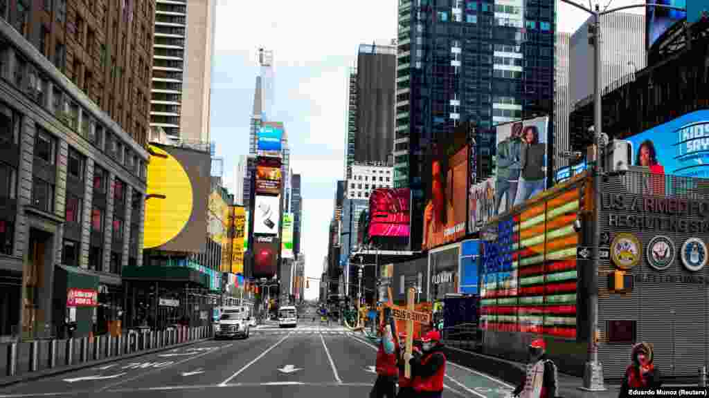 US - People walk around Times Square as the coronavirus disease (COVID-19) outbreak continues in New York, U.S., 21Mar2020