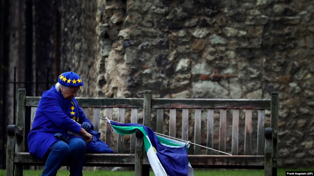 Un protestatar pro-european odihnindu-se pe o bancă, peste drum de Parlamentul Britanic din Londra 