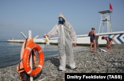 A worker in a protective suit disinfects a beach in Sochi by the Black Sea on June 22.