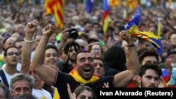 People react towards a giant screen showing events inside the Catalan regional parliament during a pro-indpendence rally outside the parliament in Barcelona, Spain October 10, 2017