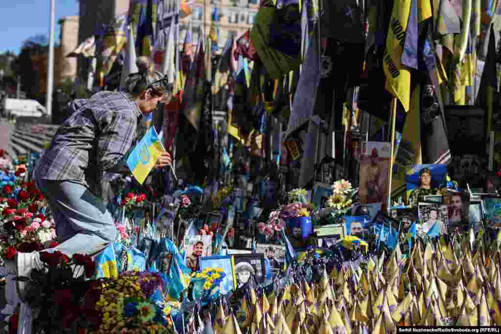 Жінка встановлює прапорець з іменем загиблої близької людини, яка поклала своє життя, захищаючи Україну 