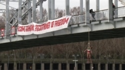 Femen Activist Hangs From Paris Bridge In Anti-Rohani Protest