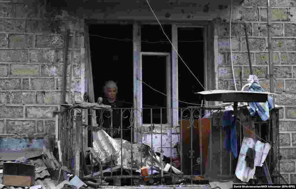 A woman looks out the window of an apartment house after shelling by Azerbaijani artillery in Stepanakert, the main city in the breakaway region of Nagorno-Karabakh, on October 4. (epa-EFE/David Ghahramanyan)