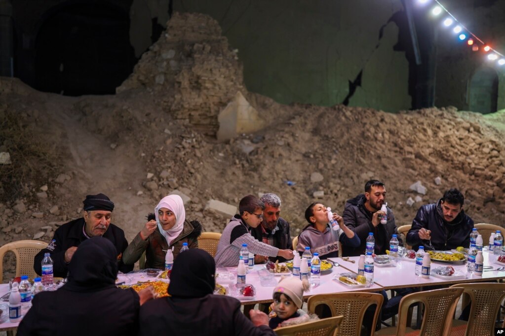Sirianët duke ngrënë një iftar të organizuar nga Fondacioni Turk Humanitar Relief (IHH), në lagjen Jobar të Damaskut, e cila u shkatërrua nga lufta.