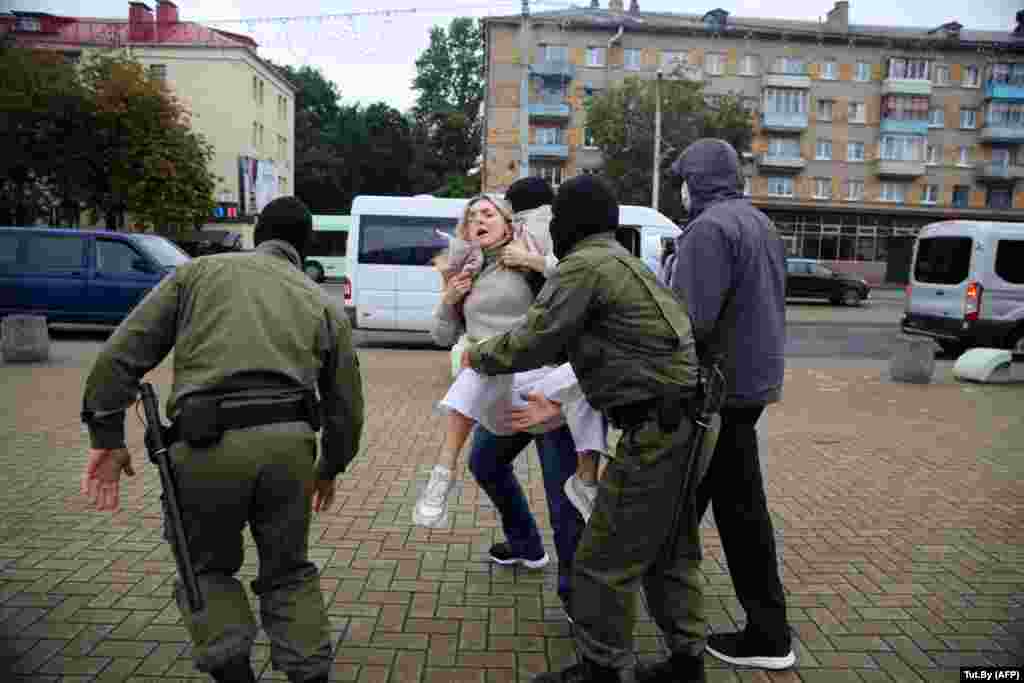 Masked officers carry away one of Kalesnikava&#39;s supporters.