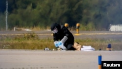 Experții germani luând probe pe aeroportul din Leipzig după ce o dronă cu explozivi a fost găsită în preajma aeronavelor de marfă ucrainene.