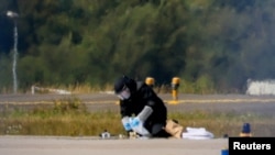 Policijski službenik u zaštitnoj opremi pregledava dokaze na aerodromu u Leipzigu u Njemačkoj 5. avgusta, nakon što su zabilježena dva incidenta povezana s dronovima.