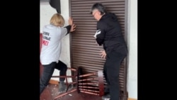 Участницы феминистской инициативы Feminita держат дверь, который пытаются выбить агрессивно настроенные люди. Скрин видео