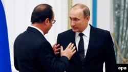 Russian President Vladimir Putin (right) and French President Francois Hollande talk after a press conference following their talks at the Kremlin in Moscow in November 2015.