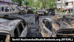 Workers clean up the debris and destruction from an overnight Russian drone attack on Kyiv on May 4.