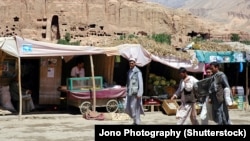 Market stalls in Bamiyan stand in front of one of the niches where the region's famed carved Buddhas, which were blown up by the Taliban in 2001, once stood.