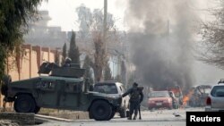 Afghan police officers arrive at the site of a blast and gun fire in Jalalabad on January 24.