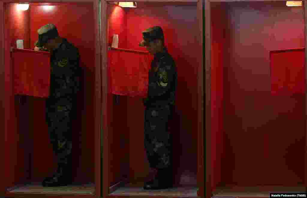 Belarusian servicemen vote in voting booths at a polling station in Minsk during early voting for the 2020 presidential election being held on August 4-8. (TASS/Natalia Fedosenko)