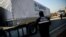 A worker stands as a Syria-bound truck, loaded with humanitarian aid, gets ready to leave a UN transhipment hub near the Turkish-Syrian border. (file photo)