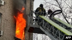 Співробітники ДСНС ліквідовують пожежу в житловому будинку після атаки російських безпілотників на Київ, 1 січня 2025 року