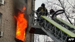 A Ukrainian firefighter tackles a blaze in a residential building following a Russian drone attack on Kyiv on January 1. 