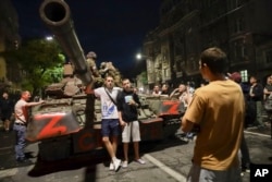 Жители на Ростов на Дон позират пред танк, върху който се виждат бойци от "Вагнер"