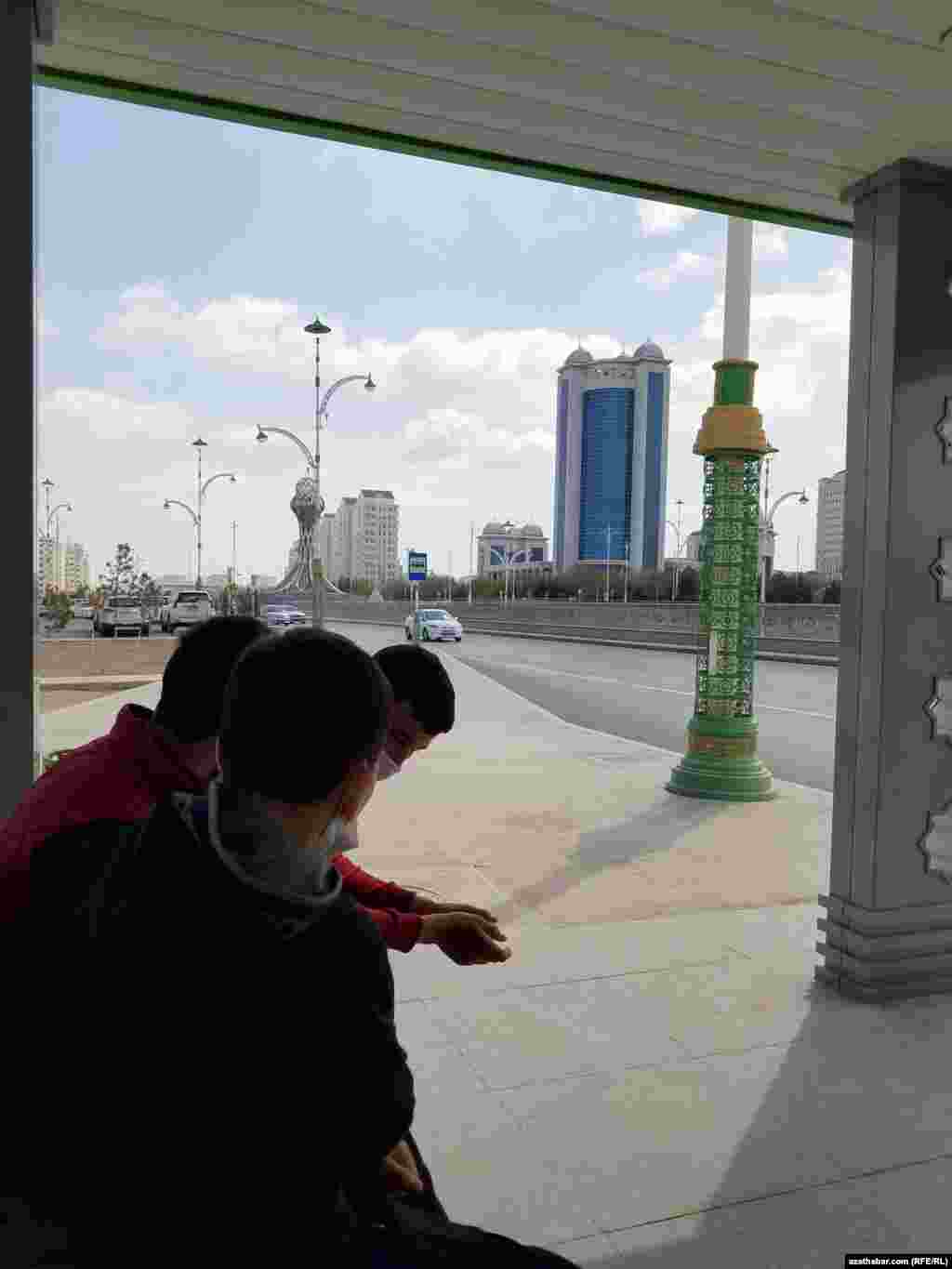 Awtobus duralgasyndaky maskaly oglanlar. Aşgabat, aprel, 2021.