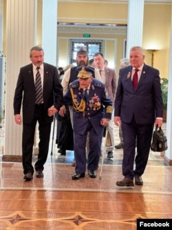 Three of the alleged conspirators -- Raul Lupu (left), Christian Atitiene (second left), and Stefan Mateescu (right) -- accompany 102-year-old retired general Radu Theodoru at the Russian Embassy in Bucharest on February 20. The embassy posted the photo on its Facebook page.