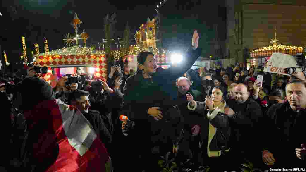 Szalome Zurabicsvili volt georgiai elnök, a kormányellenes demonstrációk legjelentősebb politikai támogatója üdvözli a tüntetőket december 25-én. Zurabicsvili vitatja Kavelasvili elnökségét, továbbra is önmagát tartja elnöknek, amíg &ndash; mint mondja &ndash; meg nem választják törvényes utódját